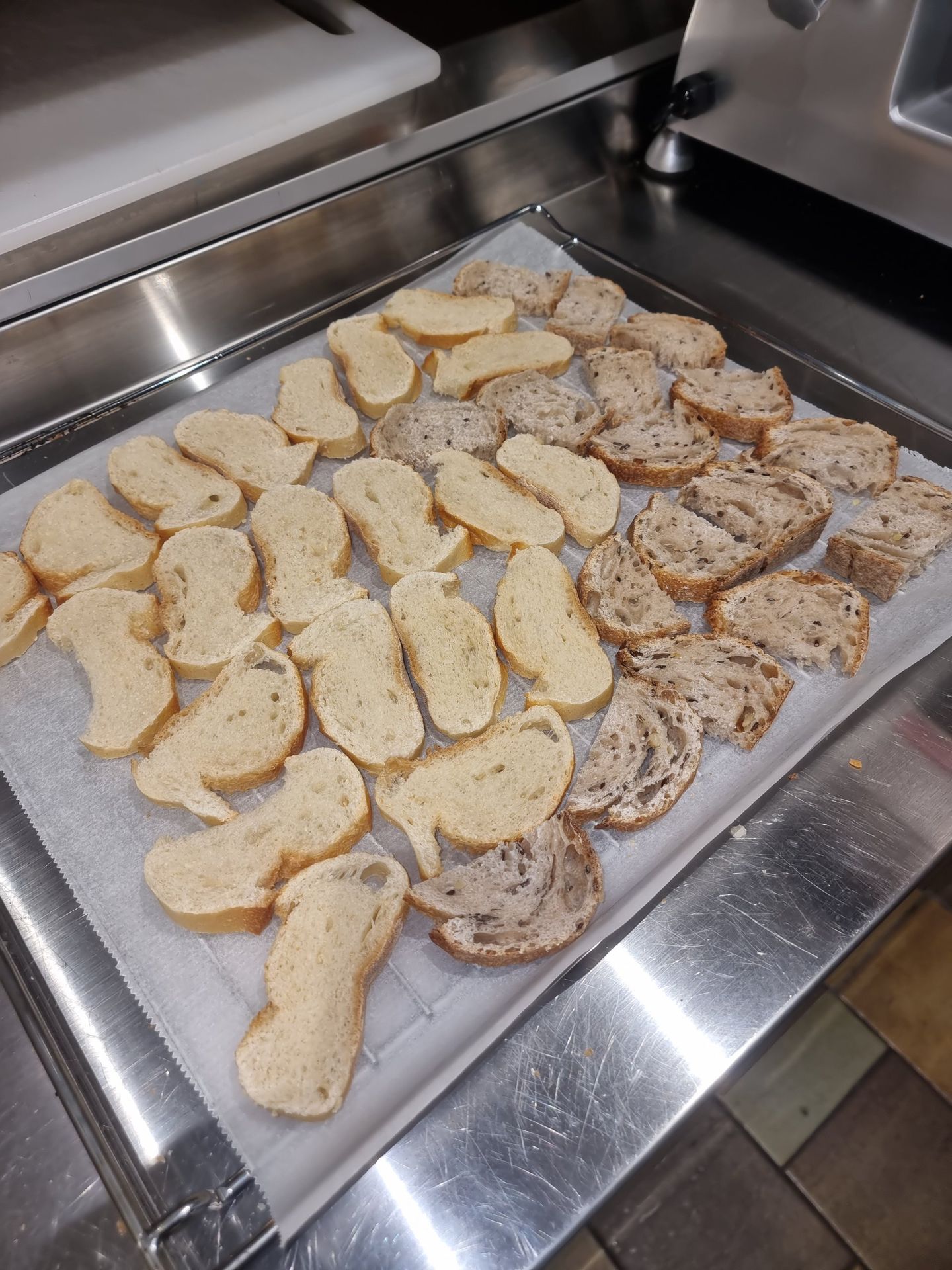 Tranches de pain disposées sur plaque avant cuisson